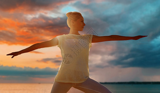 健身,运动,瑜伽健康的生活方式妇女战士姿态海上日落背景女人海上日落时战士的姿势图片