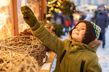 假期,童人的快乐的小男孩选择诞装饰品诞市场冬季晚上冬天诞节市场上快乐的小男孩图片