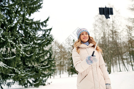 人们,季节休闲快乐的微笑女人冬天用自拍杆拍照女人冬天用自拍杆拍照图片