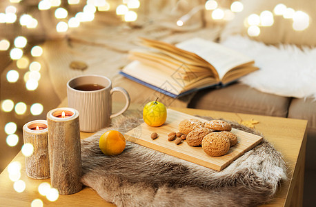 潮湿舒适的家庭燕麦片饼干,柠檬茶蜡烛木制桌子客厅饼干,柠檬茶蜡烛家里的桌子上图片