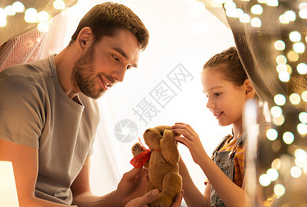 家庭,潮格人们的快乐的父亲与泰迪熊玩具小女儿玩孩子帐篷晚上家快乐的家庭孩子们的帐篷里玩玩具图片