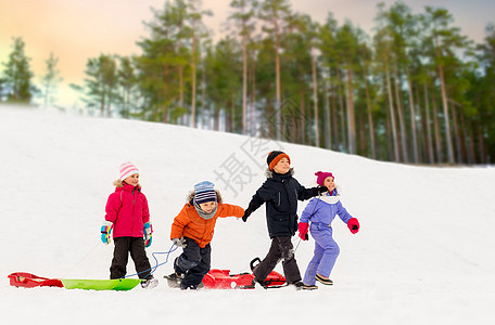 童,雪橇季节的群快乐的孩子与雪橇冬季森林背景快乐的小孩子冬天带着雪橇图片