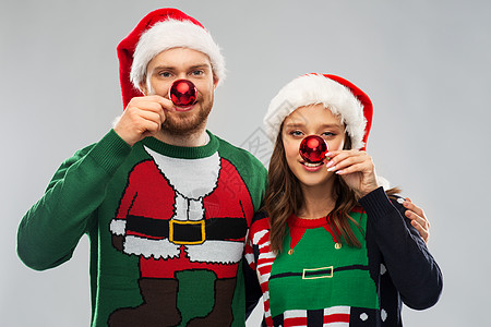 人们节日的幸福的夫妇戴着诞老人的帽子,毛衣派上用红色诞球的鼻子诞毛衣诞帽的幸福夫妇图片
