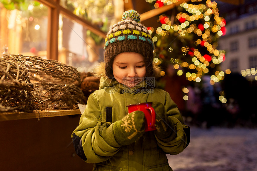 假期,童人们的快乐的小男孩诞市场冬天的晚上喝茶快乐的男孩诞市场喝杯茶图片