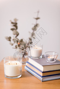 装饰,舒适的香味蜡烛燃烧璃架书籍上的木制桌子香烛燃烧,桌上书图片
