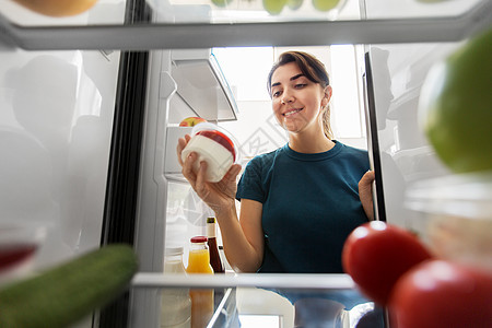 健康的饮食,食物饮食快乐的女人冰箱里酸奶家厨房快乐的女人家里冰箱里食物图片
