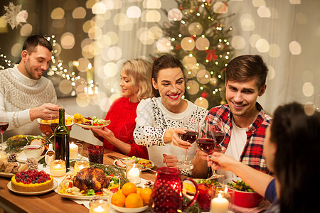 宴会干杯节日庆祝快乐的朋友家里吃诞晚餐,喝红酒碰杯快乐的朋友诞节聚会上喝红酒背景