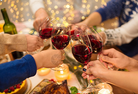 朋友干杯节日庆祝亲密的朋友家里吃诞晚餐,喝红酒碰杯亲密的朋友用葡萄酒庆祝诞节背景