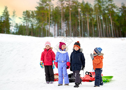 童,雪橇季节的群快乐的孩子与雪橇冬季森林背景快乐的小孩子冬天带着雪橇图片