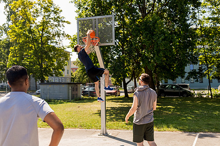 男人街头篮球场跳来扣篮背景图片