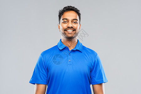 情感,表情人的微笑的印度男子穿着蓝色马球衫灰色背景穿着蓝色马球衫的印度男人,灰色背景背景图片