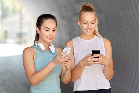 健身,运动健康的生活方式微笑的轻妇女女朋友与智能手机智能手机的女女朋友图片