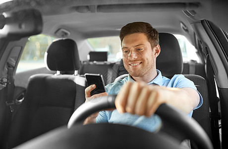 运输,车辆技术微笑的人司机驾驶汽车用智能手机开车用智能手机的人图片
