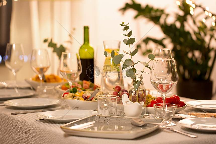 庆祝,假日,餐饮饮食桉树桌子上提供盘子,酒杯食物的家庭晚餐聚会桌子上盘子酒杯食物图片