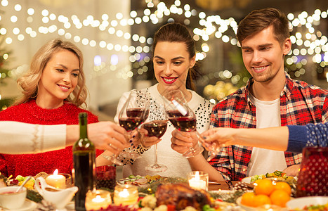 宴会干杯节日庆祝快乐的朋友家里吃诞晚餐,喝红酒碰杯快乐的朋友诞节聚会上喝红酒背景