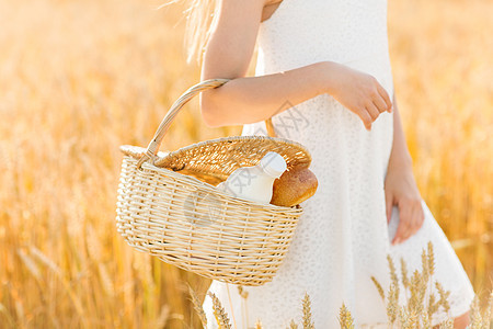 自然,健康的饮食机的轻女孩着柳条篮子与包牛奶谷物场夏天谷物地里篮子里包牛奶的女孩图片