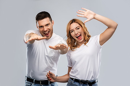 关系人的幸福的夫妇白色T恤跳舞灰色背景的肖像穿着白色T恤跳舞的幸福夫妇的肖像图片