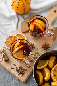 诞节季节饮料锅与热覆盖葡萄酒,橙色片,芳香香料瓢灰色背景锅里热覆盖的葡萄酒橘子片香料图片