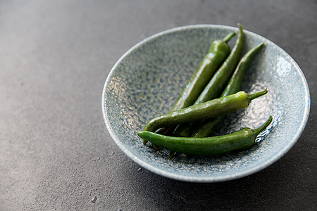 蔬菜,食物烹饪绿色辣椒陶瓷碗石板石背景把绿色辣椒关碗里图片