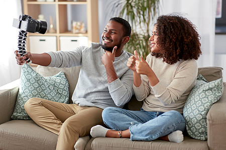 博客,视频博客人的快乐的非裔美国人夫妇的视频博客与相机视频博客家里竖大拇指几个视频博主带着相机家图片