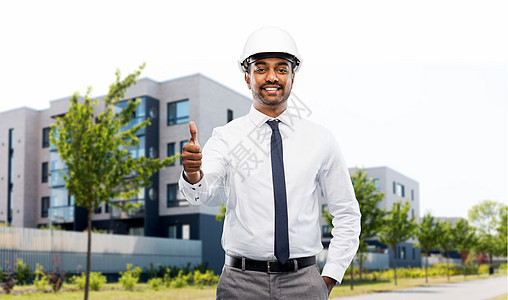 建筑,建筑业务人的微笑的印度男建筑师头盔竖大拇指城市街道背景的居住房屋建筑师城市街道上竖大拇指背景图片