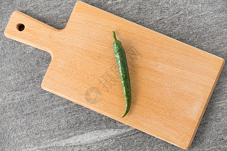 蔬菜,食物烹饪绿色辣椒木制切割板石板石背景木制砧板上的绿色辣椒图片
