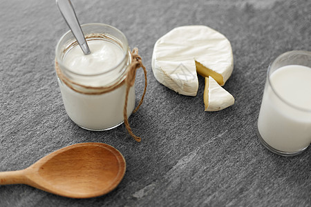 牛奶奶酪食物饮食白色奶酪,杯牛奶,自制酸奶石桌上的木勺白色奶酪,自制酸奶,牛奶勺子背景