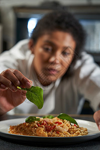 女厨师专业厨房里装饰盘子的食物图片