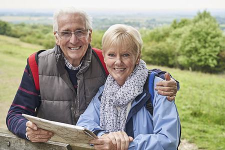 退休夫妇步行假期休息的肖像与大门上图片