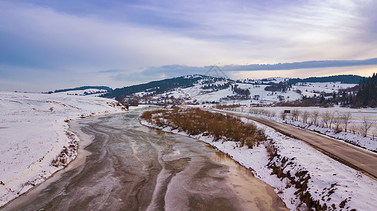 冰冻的冬季河流雪村道路的空中乡村景观早春冰雪融化图片