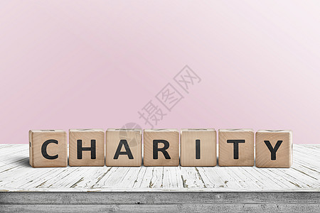 慈善标志个木制桌子上,背景粉红色的墙图片