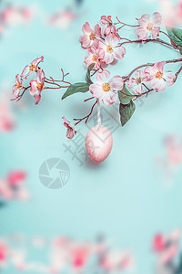 漂亮的复活节背景柔的颜色春天的花枝与粉红色悬挂复活节彩蛋浅蓝色复活节贺卡图片