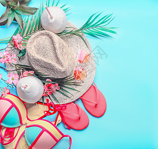夏季背景,女夏季海滩配饰椰子饮料的最佳视野比基尼拖鞋太阳镜草帽棕榈叶绿松石蓝色的热带花卉图片