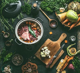 烹饪锅中的生肉厨房的桌子背景与蔬菜,调味品厨房用具,顶部视图平躺肉菜食谱肉汤,肉骨汤烹饪准备图片