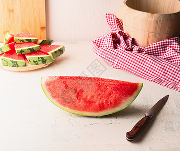 创意西瓜背景块西瓜放墙上背景的白色桌子上,用刀多汁清爽的夏季食物背景