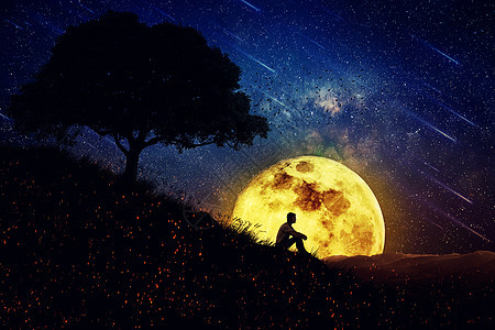 男孩独自坐自然中心的座小山上,满月的夜晚背景上远离人群,等待大自然的治愈力量图片