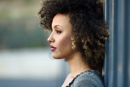 轻的混合女,留着AFRO发型,站城市背景中穿休闲衣服的黑人女孩图片