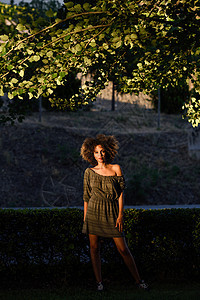轻的黑人女,留着AFRO发型,站城市背景中穿着休闲衣服的混合女孩图片