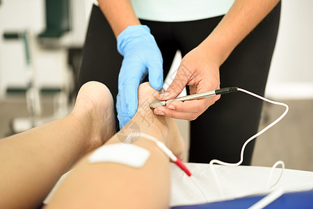 电针干针连接机,针灸师用于女患者针刺,由EPI内经皮电钻引导理疗中心名轻女子踝关节物理治疗中的电刺激图片