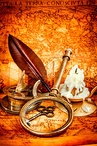 老式指南针,放大镜,怀表,羽毛笔,望远镜躺1565的张古老的上,支点燃的蜡烛复古的静物图片