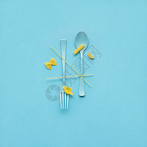 创意静物照片的叉子勺子与生意蓝色背景背景图片