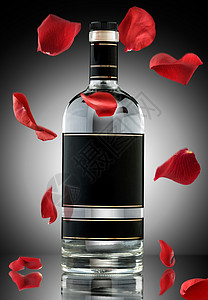 张带掉落玫瑰叶的豪华酒精瓶的照片高清图片