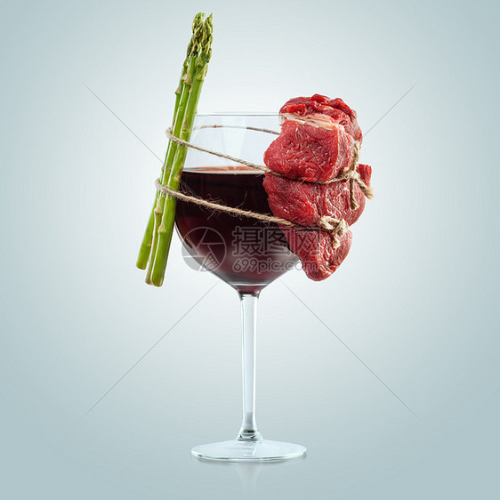创意食品照片的璃酒肉芦笋与绳子绑蓝色背景图片