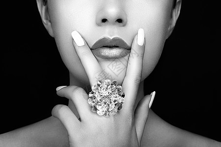 美丽时尚的女人嘴唇与自然化妆白色指甲油唇膏美女脸贴着感的嘴唇,修指甲,化妆戒指上宝石,珠宝图片