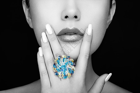 美丽时尚的女人嘴唇与自然化妆白色指甲油唇膏美女脸贴着感的嘴唇,修指甲,化妆戒指上宝石,珠宝图片