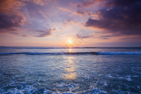 日落海洋上美丽的日落天空背景前溅海浪图片