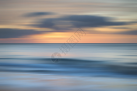 惊人的长曝光模糊日出陆地田园诗般的宽港湾海滩彭布罗克郡海岸威尔士背景图片