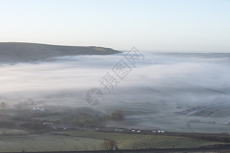 美丽的雾状英国乡村景观日出冬天,层层滚动田野背景图片