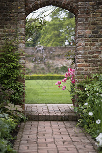 牌坊古老的英国乡村花园景观春天与郁金香边境植物图片