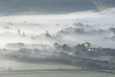 令人惊叹的雾状英国乡村景观日出冬季美丽的雾状英国乡村景观日出冬天,层层滚动田野背景图片